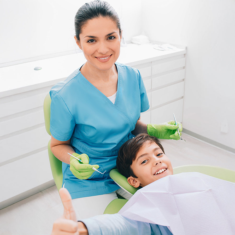 Visite d’un enfant chez le dentiste Un enfant est assis dans un cabinet dentaire en préparation d’un examen. L’image symbolise les contributions PRO LIFE pour les frais dentaires des enfants et adolescents, y compris les traitements des malpositions dentaires et maxillaires.