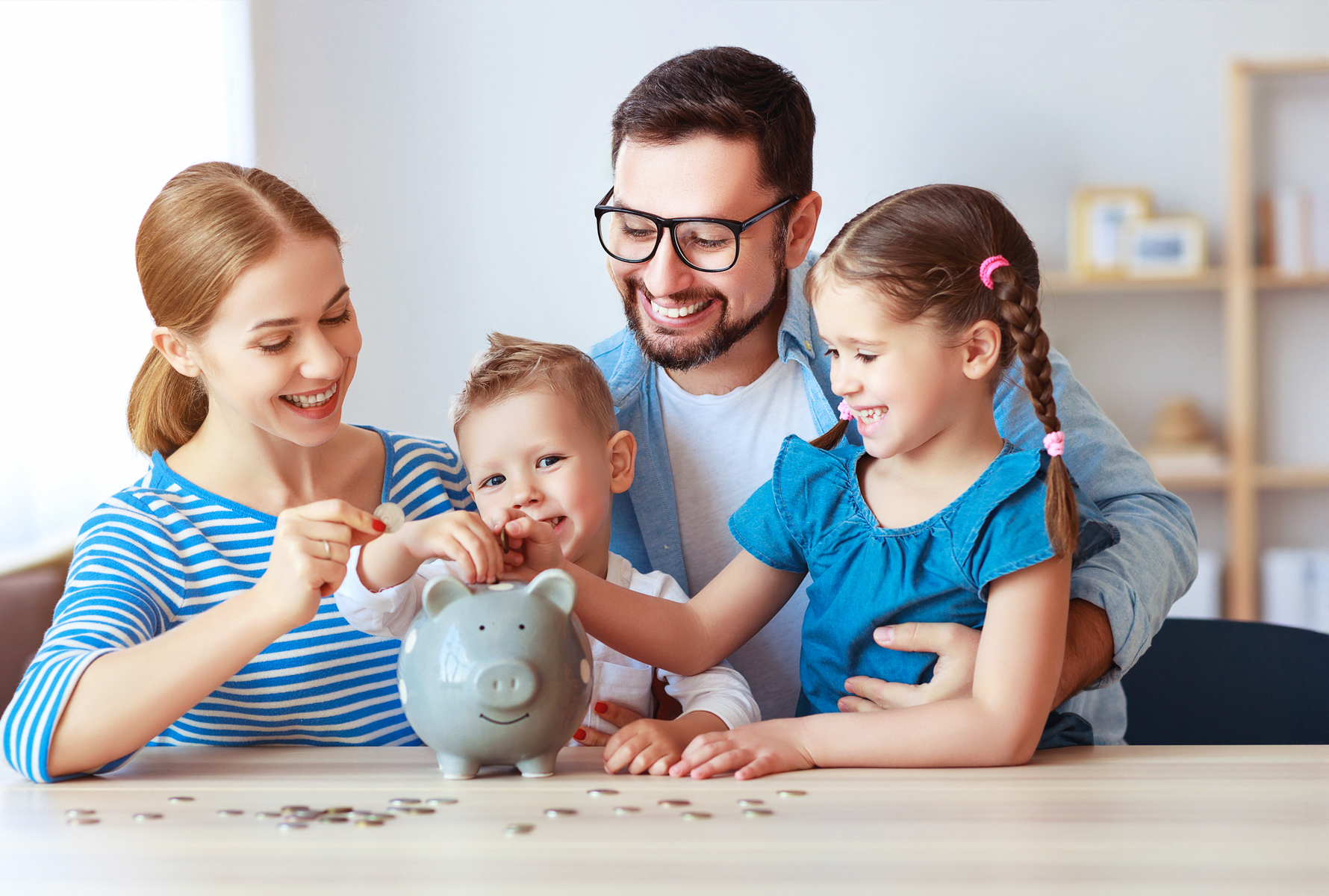 Risparmiare con metodo Una famiglia mette insieme delle monete nel salvadanaio – un’immagine del sollievo finanziario che PRO LIFE offre concretamente alle famiglie.