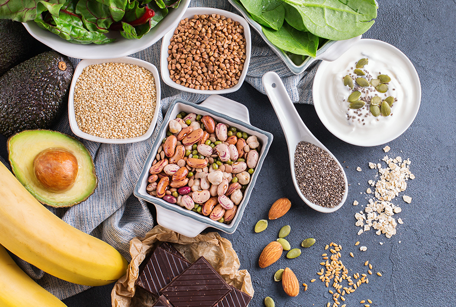 Magnesiumreiche Lebensmittel Verschiedene magnesiumreiche Lebensmittel wie Hülsenfrüchte, Quinoa, Quark, Spinat, Bananen und Mandeln – ideal zur Vorbeugung von Krämpfen und Müdigkeit.