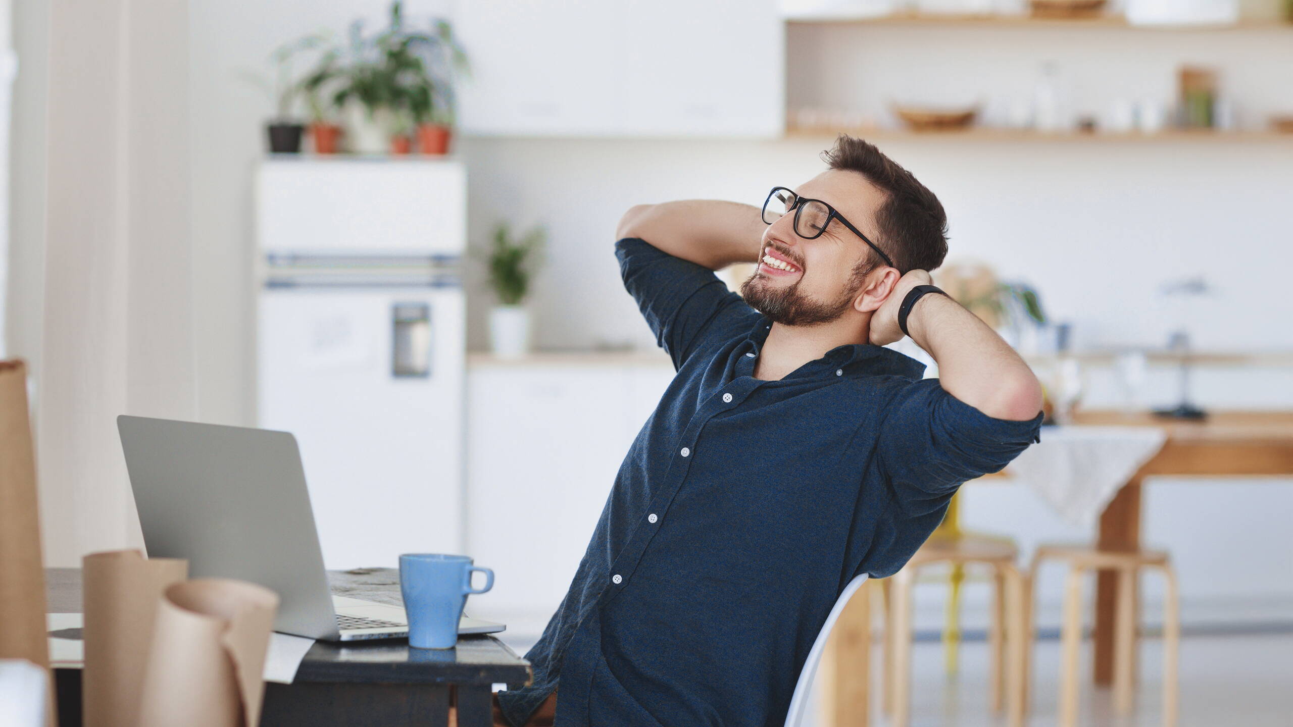Un homme s’adosse, détendu, dans son fauteuil de bureau – une image de soulagement, de sécurité et de confiance en une communauté forte.