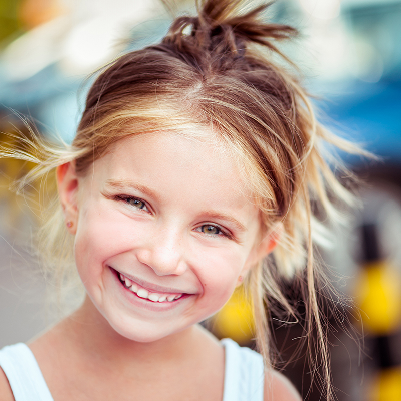 Lächelndes blondes Mädchen Ein hübsches blondes Mädchen lächelt in die Kamera – PRO LIFE beteiltigt sich an den Kosten für Zahnbehandlung mit 60%.