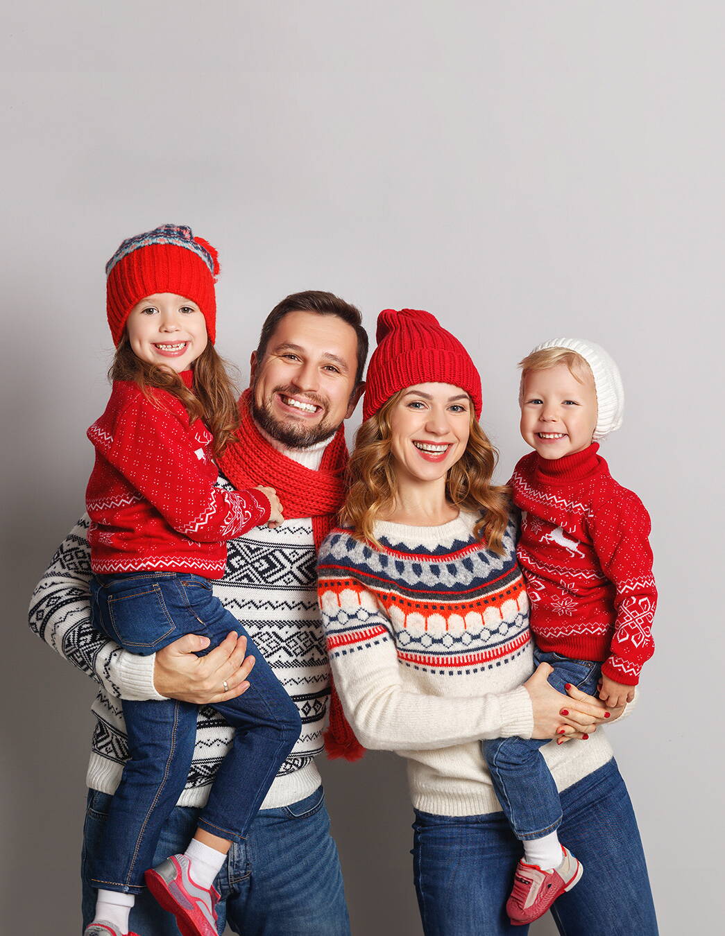 Familienzeit im Winter Eine vierköpfige Familie in Norwegerpullovern und Strickmützen geniesst gemeinsam die kalte Jahreszeit – ein Bild von Wärme, Zusammenhalt und Tradition.