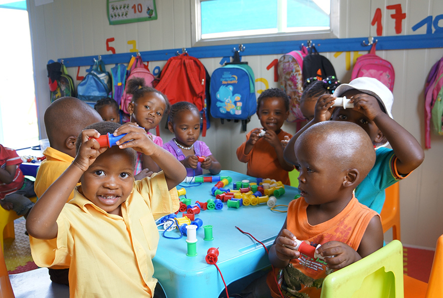 Kinder der KITA Nkululeko spielen mit bunten Rollen – ein lebendiges Bild davon, was Solidarität und Spenden möglich machen.