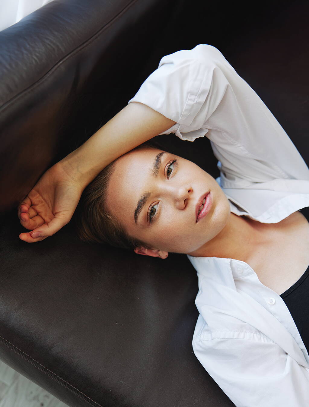 Eine schwangere Frau ruht sich auf dem Sofa aus – ein Symbol für das starke Ruhebedürfnis, das viele Schwangere in der Frühphase empfinden.