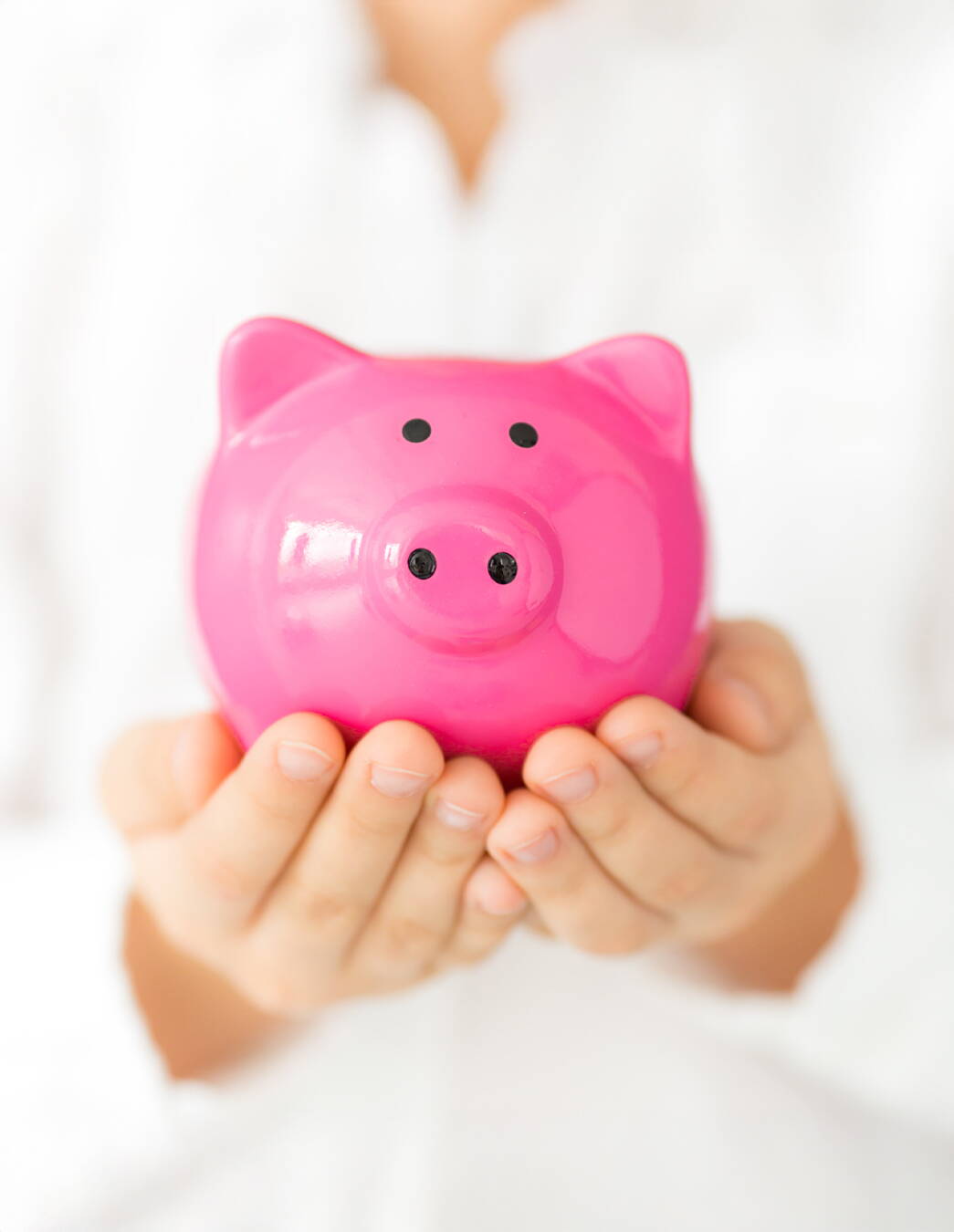 Une personne porte précautionneusement une tirelire rose sur ses paumes ouvertes – une image de vigilance, confiance et gestion durable de vos cotisations.