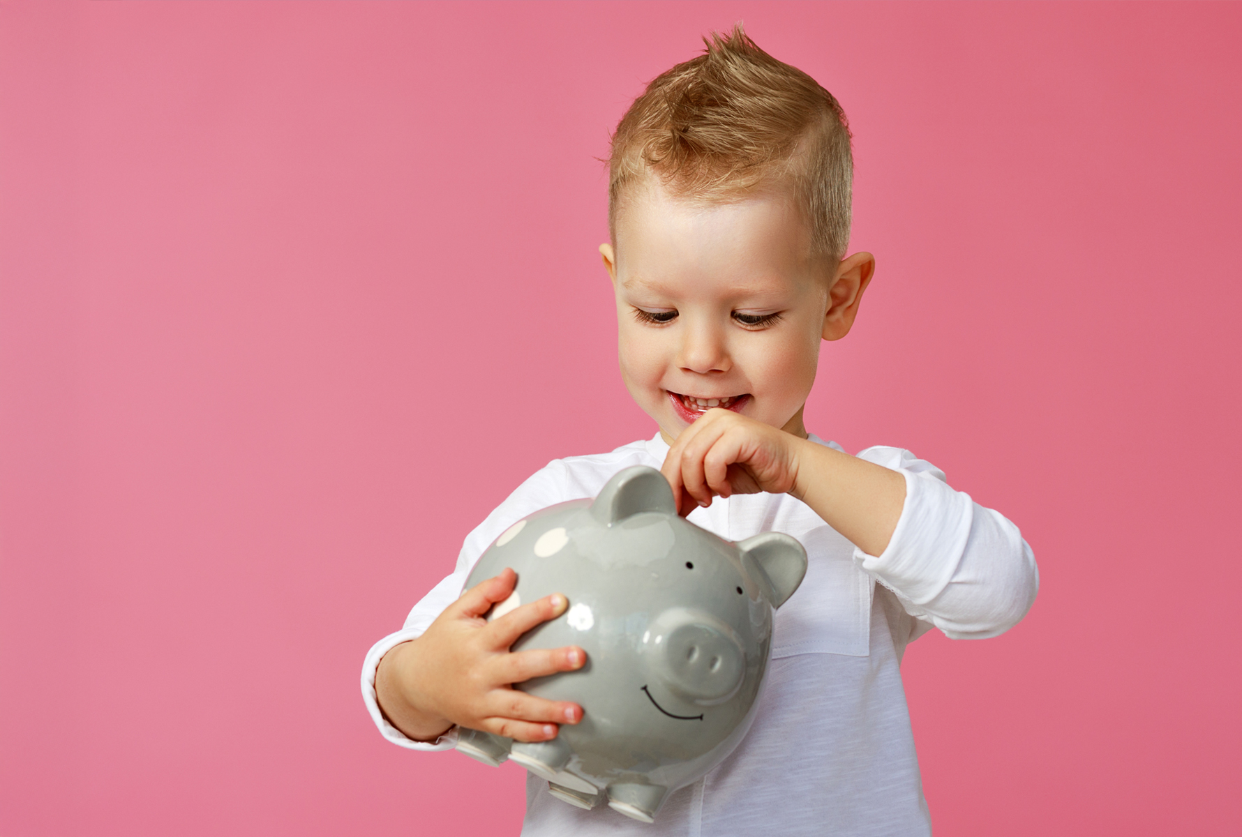 Einfach helfen Der kleine Junge steckt eine Münze in sein Sparschwein – so einfach kann Solidarität sein.