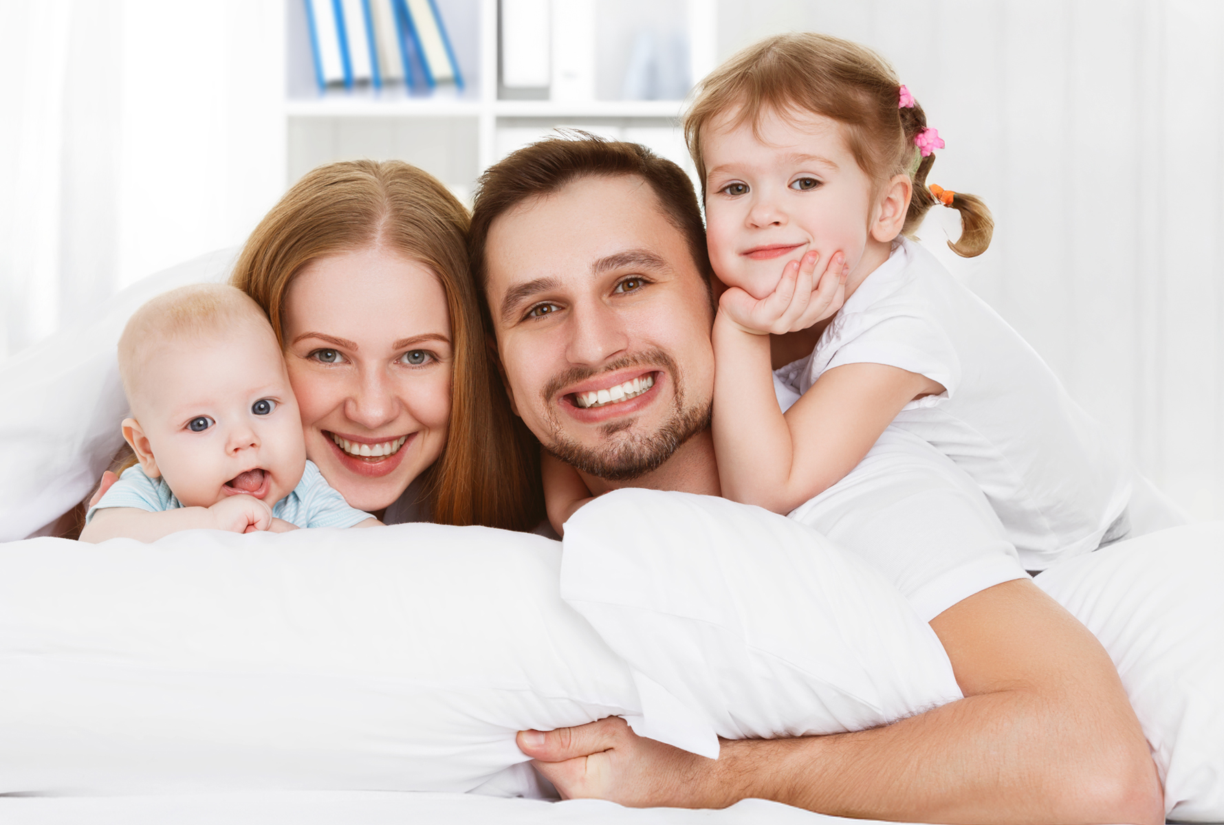 Une famille composée d’un père, d’une mère et de deux enfants sourit à la caméra – symbole de cohésion et de joie de vivre.