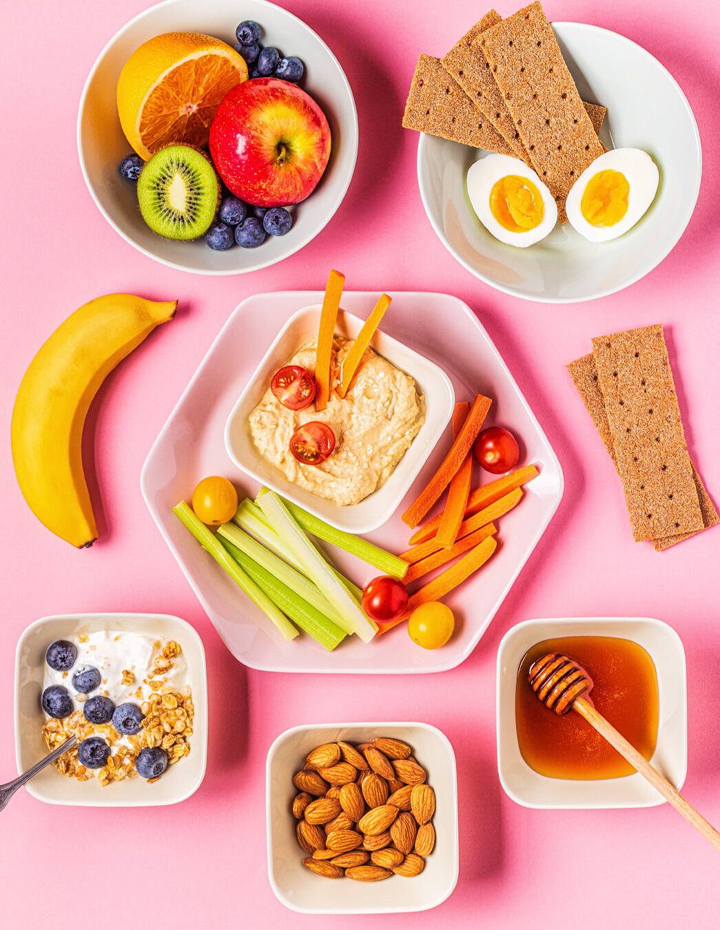 Gesunde Snacks gegen Heisshunger Ein gesunder Mix aus Hummus mit Gemüse, frischen Früchten, Nüssen, Honig, Vollkornknäckebrot und Ei – ideal, um Heisshungerattacken in der Schwangerschaft zu begegnen.