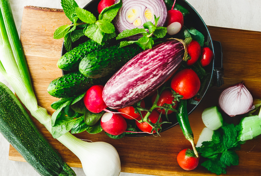 Bunte Vielfalt auf dem Teller Sie sehen eine Auswahl an frischem Gemüse wie Gurken, Radieschen und Auberginen – perfekt für eine ausgewogene Ernährung.