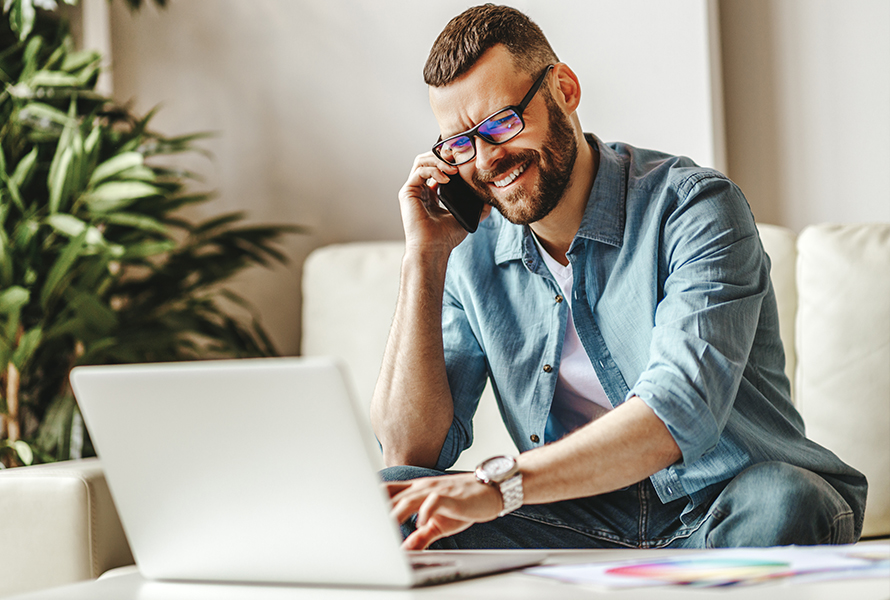 Un lien direct avec nous Un homme travaille concentré sur son ordinateur portable et téléphone – un contact simple pour vos demandes.