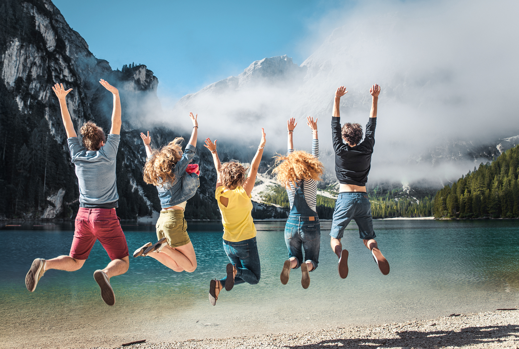 Portail loisirs MiBon Un groupe de jeunes saute en l’air – derrière, un lac et des montagnes. MiBon rend les moments partagés plus riches et plus abordables.